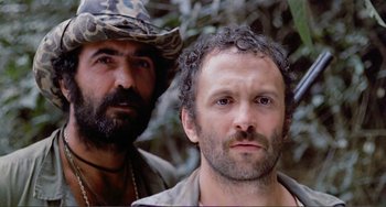 Movie still from “Cannibal Holocaust” (1980), directed by Ruggero Deodato – A man with a beard and a man with a hat; Close Up shot, Low angle