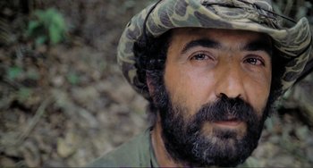 Movie still from “Cannibal Holocaust” (1980), directed by Ruggero Deodato – A person wearing a hat; Close Up shot, Low angle