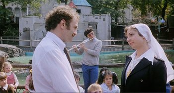 Movie still from “Cannibal Holocaust” (1980), directed by Ruggero Deodato – A man and a woman playing a flute in a zoo; Medium shot, Over the shoulder angle