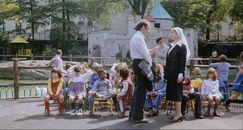 Movie still from “Cannibal Holocaust” (1980), directed by Ruggero Deodato – A group of people standing around a crowd of children; Wide shot, High angle