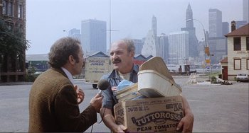 Movie still from “Cannibal Holocaust” (1980), directed by Ruggero Deodato – An older man is talking to an older man in the street; Medium shot, Over the shoulder angle