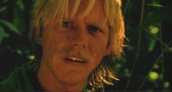 Movie still from “Cannibal Holocaust” (1980), directed by Ruggero Deodato – A person with long blonde hair; Close Up shot, Low angle