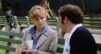 Movie still from “Cannibal Holocaust” (1980), directed by Ruggero Deodato – A woman and a man sitting on a park bench talking; Medium shot, Over the shoulder angle