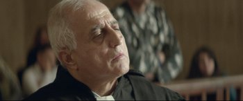Movie still from “Capernaum” (2018), directed by Nadine Labaki – An older man sitting in front of another man; Close Up shot, Low angle