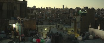 Movie still from “Capernaum” (2018), directed by Nadine Labaki – A view of a city at night from a roof top; Extreme Wide shot, Over the shoulder angle