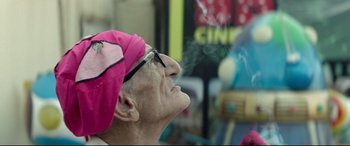 Movie still from “Capernaum” (2018), directed by Nadine Labaki – An older woman wearing glasses and a pink hat is smoking; Close Up shot, Low angle