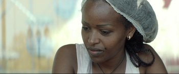 Movie still from “Capernaum” (2018), directed by Nadine Labaki – A person wearing a white tank top; Close Up shot, Over the shoulder angle