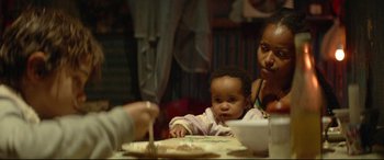 Movie still from “Capernaum” (2018), directed by Nadine Labaki – A woman and a baby at a table cutting a cake; Close Up shot, Over the shoulder angle