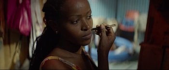 A woman putting makeup on her face