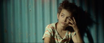 Movie still from “Capernaum” (2018), directed by Nadine Labaki – A young boy sitting in front of a blue wall; Close Up shot, Low angle