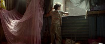 Movie still from “Capernaum” (2018), directed by Nadine Labaki – A young boy standing in front of a window; Medium shot, Low angle