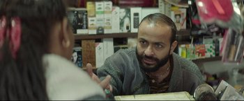 Movie still from “Capernaum” (2018), directed by Nadine Labaki – A man talking to another man in a store; Close Up shot, Over the shoulder angle