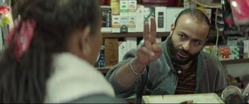 Movie still from “Capernaum” (2018), directed by Nadine Labaki – Two people sitting at a table in front of each other; Medium shot, Over the shoulder angle