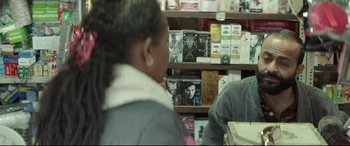 Movie still from “Capernaum” (2018), directed by Nadine Labaki – A woman sitting in front of a book shelf; Close Up shot, Over the shoulder angle