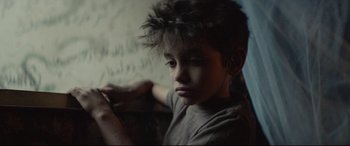 Movie still from “Capernaum” (2018), directed by Nadine Labaki – A young boy sitting in front of a chalkboard; Close Up shot, Over the shoulder angle