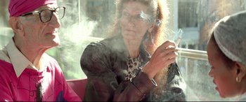 Movie still from “Capernaum” (2018), directed by Nadine Labaki – A woman smoking a cigarette in front of a window; Medium shot, Low angle