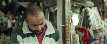 Movie still from “Capernaum” (2018), directed by Nadine Labaki – A man with a beard is standing in front of a window; Close Up shot, Over the shoulder angle
