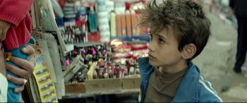 Movie still from “Capernaum” (2018), directed by Nadine Labaki – A young boy is standing in front of a display of cosmetics; Close Up shot, Over the shoulder angle