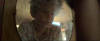 Movie still from “Capernaum” (2018), directed by Nadine Labaki – A young boy is looking out a window at night; Close Up shot, Low angle
