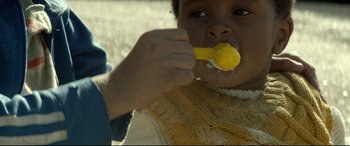 Movie still from “Capernaum” (2018), directed by Nadine Labaki – A child is eating a corn cob with a spoon in his mouth; Close Up shot, Over the shoulder angle