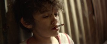 Movie still from “Capernaum” (2018), directed by Nadine Labaki – A woman is smoking a cigarette in a room; Close Up shot, High angle