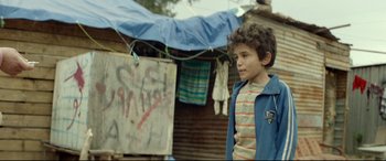 Movie still from “Capernaum” (2018), directed by Nadine Labaki – A young boy standing in front of a building; Medium shot, Over the shoulder angle