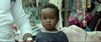 Movie still from “Capernaum” (2018), directed by Nadine Labaki – A little boy that is standing up in the street; Close Up shot, Over the shoulder angle