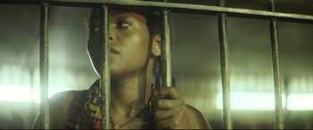 Movie still from “Capernaum” (2018), directed by Nadine Labaki – A woman is behind bars in a jail cell; Close Up shot, Low angle