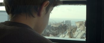 Movie still from “Capernaum” (2018), directed by Nadine Labaki – A young boy looking out of a window at the beach; Close Up shot, Over the shoulder angle