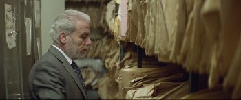 Movie still from “Capernaum” (2018), directed by Nadine Labaki – A man in a suit and tie looking at a stack of papers; Close Up shot, Low angle