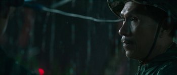 Movie still from “Cave Rescue” (2022), directed by Tom Waller – A man's face in the dark; Close Up shot, Low angle