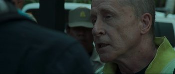 Movie still from “Cave Rescue” (2022), directed by Tom Waller – An old man with a hat on looking into the distance; Close Up shot, Over the shoulder angle
