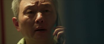 Movie still from “Cave Rescue” (2022), directed by Tom Waller – A woman is looking at the camera while holding a cell phone to her ear; Extreme Close Up shot, Low angle