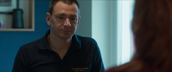 Movie still from “Cave Rescue” (2022), directed by Tom Waller – A person sitting in a room; Close Up shot, Over the shoulder angle