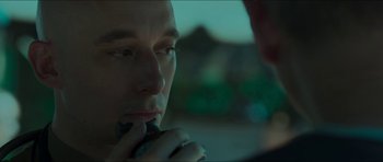 Movie still from “Cave Rescue” (2022), directed by Tom Waller – A person holding a cell phone to his ear; Close Up shot, Over the shoulder angle