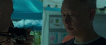 Movie still from “Cave Rescue” (2022), directed by Tom Waller – An older man looking down at his cell phone; Close Up shot, Low angle