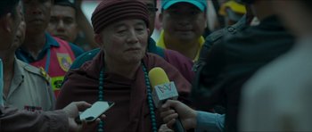 Movie still from “Cave Rescue” (2022), directed by Tom Waller – An older man is being interviewed by a man holding a microphone; Close Up shot, Over the shoulder angle