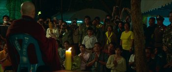 Movie still from “Cave Rescue” (2022), directed by Tom Waller – A group of people gathered around a lit candle; Extreme Wide shot, Over the shoulder angle