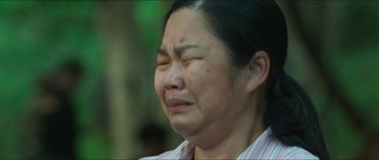 Movie still from “Cave Rescue” (2022), directed by Tom Waller – A person crying with her eyes closed; Close Up shot, Low angle