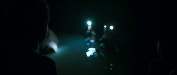 Movie still from “Cave Rescue” (2022), directed by Tom Waller – A blurry image of a person riding a motorcycle at night; Medium shot, Over the shoulder angle