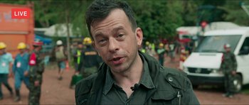 Movie still from “Cave Rescue” (2022), directed by Tom Waller – A person wearing a jacket; Close Up shot, Over the shoulder angle