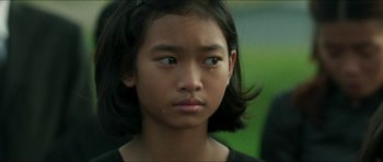 Movie still from “Cave Rescue” (2022), directed by Tom Waller – A young person with long black hair; Close Up shot, Over the shoulder angle