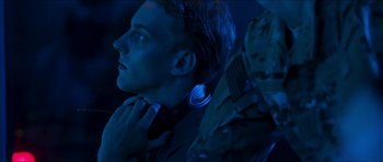 Movie still from “Cave Rescue” (2022), directed by Tom Waller – A young man with a blue light around his neck; Close Up shot, Over the shoulder angle