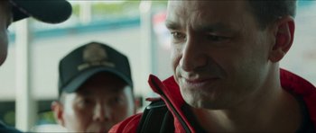 Movie still from “Cave Rescue” (2022), directed by Tom Waller – A person wearing a red jacket; Close Up shot, Over the shoulder angle
