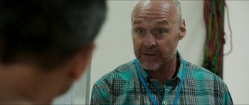 Movie still from “Cave Rescue” (2022), directed by Tom Waller – An older man is looking at himself in the mirror; Close Up shot, Over the shoulder angle