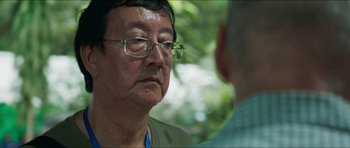 Movie still from “Cave Rescue” (2022), directed by Tom Waller – A man wearing glasses talking to another man; Close Up shot, Over the shoulder angle