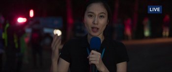 Movie still from “Cave Rescue” (2022), directed by Tom Waller – A woman is holding a microphone in her hand; Close Up shot, Low angle