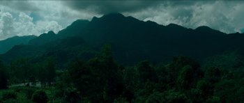Movie still from “Cave Rescue” (2022), directed by Tom Waller – A view of a mountain range with a dark sky above it; Extreme Wide shot, High angle