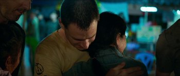 Movie still from “Cave Rescue” (2022), directed by Tom Waller – A man and a woman hugging each other in a room; Close Up shot, High angle