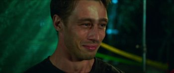 Movie still from “Cave Rescue” (2022), directed by Tom Waller – A person smiling; Close Up shot, Over the shoulder angle